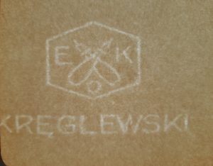 Znak wodny firmy Edwarda Kręglewskiego zaawierający dwa skrzyzowane pióra umieszczone w pięciobocznej ramce z inicjałami E.K.