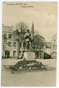 Czarnobiała pocztówka przedstawia widok na Kamienicę Mieszczańską po 1911 roku.